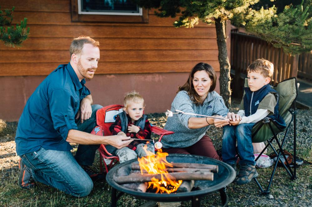 Family enjoying s'mores at a campfire at a KM Resorts campground